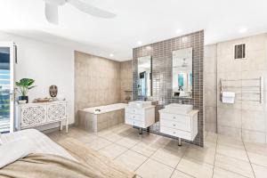a bathroom with two sinks and a tub and a shower at Alex Beach House in Alexandra Headland