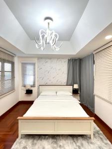 a bedroom with a large bed and a chandelier at SOVA Vcay Pool Villa 