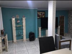 uma sala de estar com paredes azuis e uma mesa e cadeiras em casa alto padrão a 30 min da praia no Rio de Janeiro