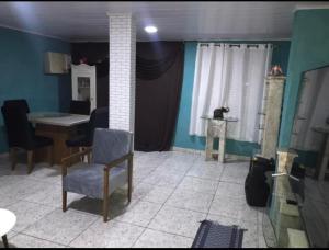uma sala de estar com uma mesa e uma cadeira em casa alto padrão a 30 min da praia no Rio de Janeiro