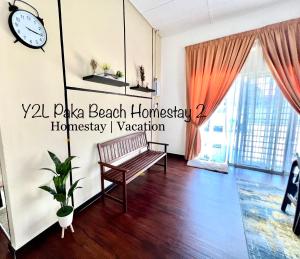 een woonkamer met een bank en een klok aan de muur bij CozyLuxury Homestay Paka 3-7pax near Paka Beach and surrounding many Restaurant - Y2L Homestay 2 in Paka