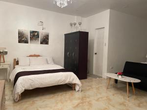 een slaapkamer met een groot bed en een tafel bij CASA DE SAN ISIDRO in Bansud