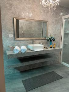 een badkamer met een wastafel en een spiegel bij CASA DE SAN ISIDRO in Bansud