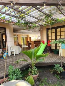 una terraza al aire libre con pérgola y algunas plantas en Fare Cocoon, en Punaauia