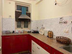uma cozinha com armários vermelhos e um lavatório em Kashi Karma Homestay em Varanasi