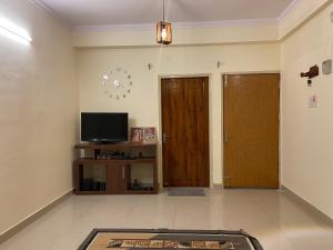a living room with two doors and a television at Kashi Karma Homestay in Varanasi
