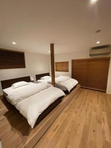 two beds in a large room with wooden floors at the terrace sumoto - Vacation STAY 24588v in Sumoto