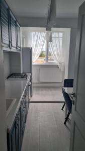 uma cozinha com um fogão, um lavatório e uma janela em Alpasio Rentals 2 em Galaţi