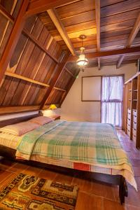 Un dormitorio con una cama grande en una habitación con techos de madera. en Chalet Lander Colonia Tovar en El Tigre