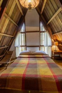 ein Schlafzimmer mit einem großen Bett im Dachgeschoss in der Unterkunft Chalet Lander Colonia Tovar in El Tigre