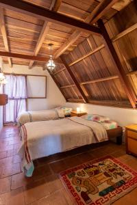 2 Betten in einem Zimmer mit Holzdecken in der Unterkunft Chalet Lander Colonia Tovar in El Tigre