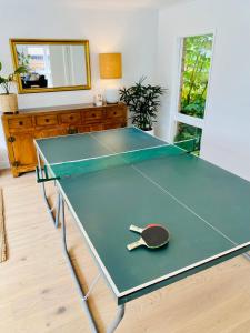 una mesa de ping pong con una paleta de ping pong en Pool & Table Tennis - Mornington Peninsula Beach House, en Frankston South