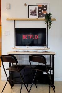 Televízia a/alebo spoločenská miestnosť v ubytovaní Relaxing Apt Bgc Business Ready with 84inch Cinema