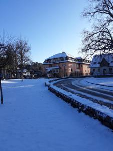 een met sneeuw bedekte straat voor een gebouw bij Haus Brandenburg in Stechlin
