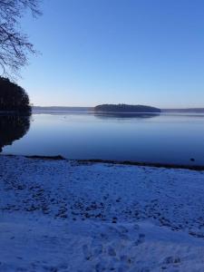 a large body of water with snow on the shore at Haus Brandenburg in Stechlin
