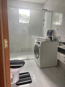 y baño con lavadora y aseo. en CABANA DOCE LUAR en Gravataí