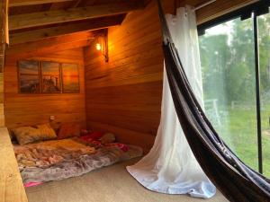 1 dormitorio con hamaca en una cabaña de madera en CABANA DOCE LUAR, en Gravataí