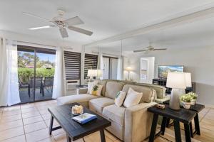 uma sala de estar com um sofá e uma mesa em Ground floor Banyon Harbor em Lihue