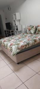 Bett mit Blumendecke in einem Schlafzimmer in der Unterkunft HayLee's Cottage in Benoni