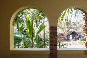 an arched window in a building with a palm tree at Acland Art Deco - Coastal Chic by St Kilda Beach in Melbourne