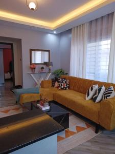 a living room with a brown couch in a room at Serene Homes 04 in Kampala