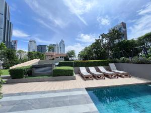 eine Terrasse mit Liegestühlen und einem Pool in der Unterkunft 市中心URBITIA 精品公寓 in Klong Toi