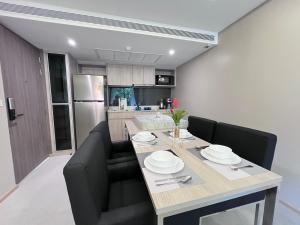 市中心URBITIA 精品公寓 في Klong Toi: مطبخ وغرفة طعام مع طاولة وكراسي