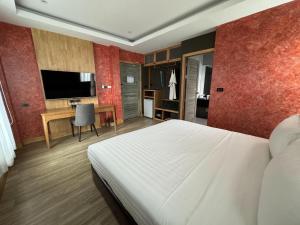 a bedroom with a bed and a desk and a television at La Isla Pranburi Beach Resort in Sam Roi Yot