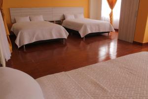 1 dormitorio con 2 camas y suelo de madera en Gran Hotel en Ipiales