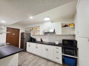 a kitchen with white cabinets and a black counter top at Ocean's Edge Suite in Campbell River