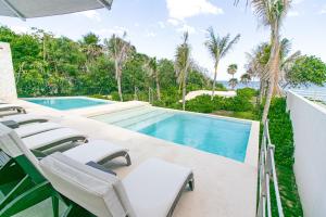 una piscina con sedie a sdraio accanto a una piscina di Casa Blanca By The Caribbean Sea ad Akumal