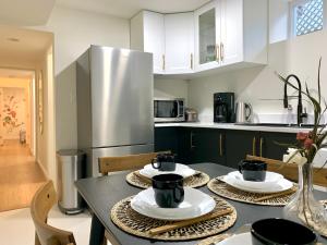 a kitchen with a table with plates and cups on it at 3Beds 2BA Cherry Blossom Suite - Free Parking - Central Oakridge Neighbourhood in Vancouver
