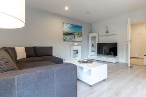 a living room with a couch and a tv at Summer Diek Summerdiek 5 in Sankt Peter-Ording