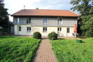 a house with a brick path in front of it at Ferienwohnung Am Apfelbaum - romantische Remise direkt am Golfplatz und der Schlei in Borgwedel