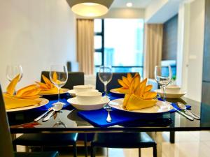 een eettafel met borden en wijnglazen bij Orion Suites@ The Robertson Bukit Bintang in Kuala Lumpur