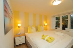a bedroom with a bed with yellow sheets and a window at Ferienwohnung An der Linde in Borgwedel