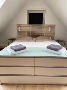 Una cama con dos toallas encima. en The Farm Guest House, en Svebølle