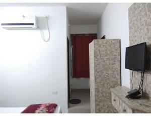 a room with a room with a television and a room with a room at Hotel Grand SM Regency, Darbhanga in Darbhanga