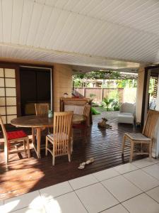 a patio with a wooden table and chairs and a table at Fare Cocoon in Punaauia