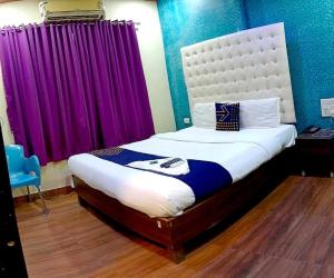 a bedroom with a large bed with purple curtains at OYO Flagship The Om Sai Residency in Mumbai