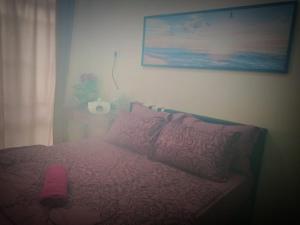 a bed with a pink comforter and a pink pillow at HOMESTAY Duranta Home's in Batu Pahat