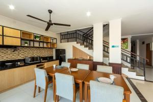 a kitchen and dining room with a wooden table and chairs at Cove Matahari Guesthouse Sunset in Legian