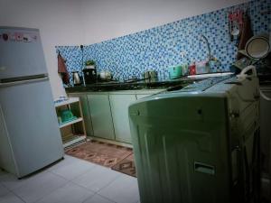 a kitchen with a stove and a refrigerator in it at HOMESTAY Duranta Home's in Batu Pahat