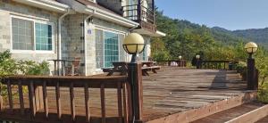 a wooden deck with benches and lights on a house at Songha Village in Jeongseon