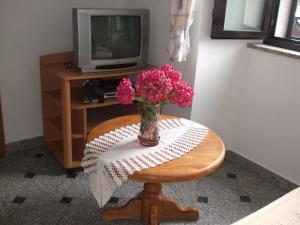 wazon różowych kwiatów na stole w obiekcie Apartment Vesna A2 w mieście Ika