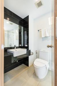 La salle de bains est pourvue de toilettes blanches et d'un lavabo. dans l'établissement Phuket Airport Condotel, à Thalang