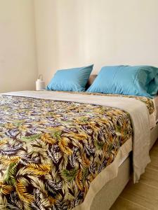 a bed with a colorful blanket on top of it at Villa TE URA Beach in Paea