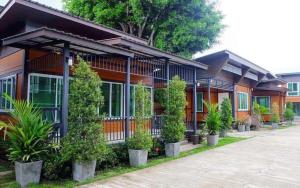 een rij huizen met planten voor hen bij TG Home Residence in Chiang Rai