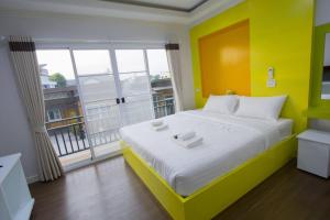 um quarto com uma cama grande e uma parede amarela em TG Home Residence em Chiang Rai