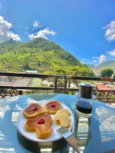 a plate of pastries on a table with a drink at Voi Hostel in Mèo Vạc